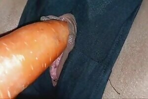 She tears off her pants to reveal her pussy hole and then masturbates by spreading her pussy and sticking a carrot into her clit until she cums.