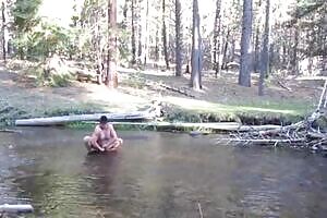 Bathing naked in the creek.